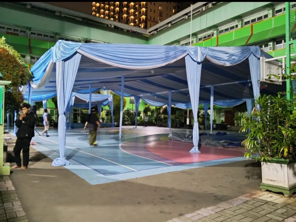 Tenda dengan dekor kain serut biru putih di halaman