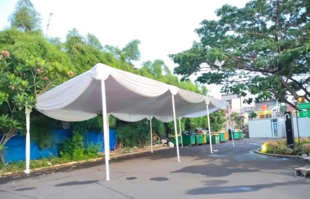 Kanopi putih dengan dekor kain serut di area taman